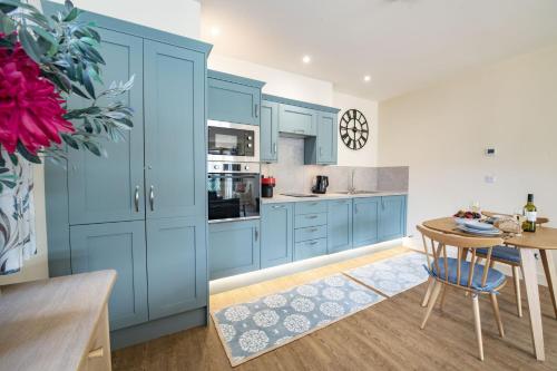 a kitchen with blue cabinets and a wooden table at Solaris in York