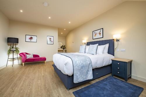 a bedroom with a large bed and a pink chair at Solaris in York