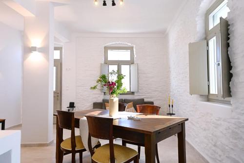 a dining room with a wooden table and chairs at Evridiki apartments in Kithnos