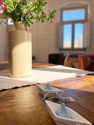 a table with a vase with flowers and two star plates at Evridiki apartments in Kithnos