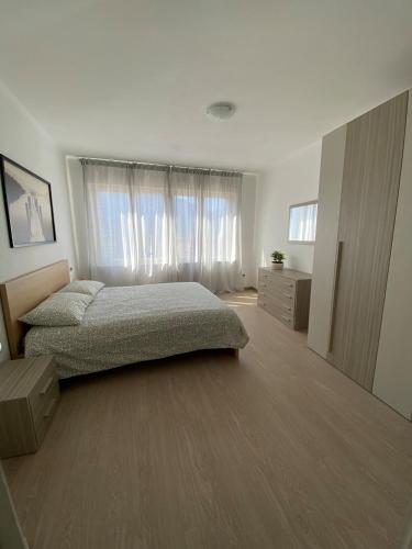 a bedroom with a bed and a large window at Amalia-Levico Terme Apartment in Levico Terme