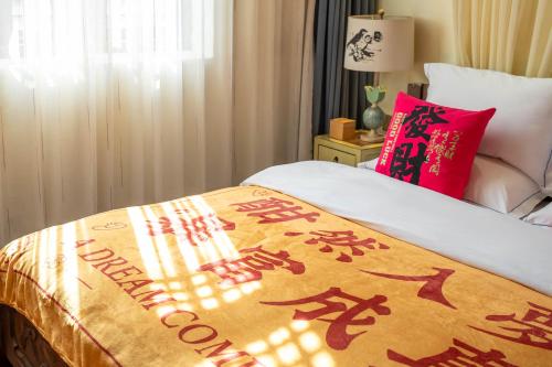 a bed with a blanket with chinese writing on it at 指云公馆Lijiang Mufu Royal Garden Resort半山观景民宿 in Lijiang