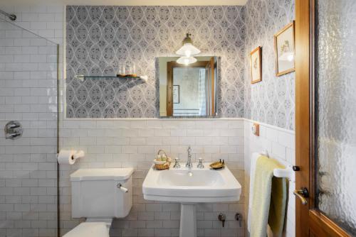 a bathroom with a sink and a toilet and a mirror at Hotel Barosse in Jaca