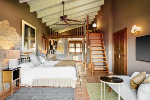 a bedroom with a bed and a staircase and a couch at Hotel Barosse in Jaca