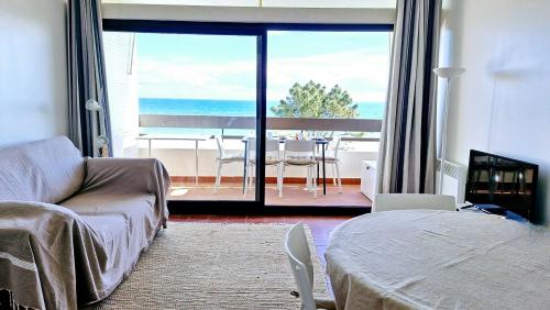 - un salon avec un lit et une vue sur l'océan dans l'établissement Paradis Bleu - Face à la mer - Wifi - parking, à Saint Cyprien Plage