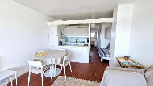 une petite cuisine avec une table et des chaises dans une pièce dans l'établissement Paradis Bleu - Face à la mer - Wifi - parking, à Saint Cyprien Plage