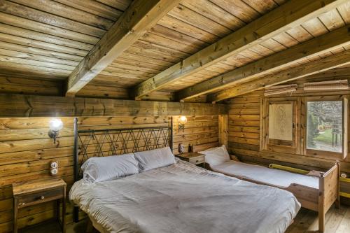 a bedroom with two beds in a log cabin at Habitacions Mas Fuselles in Girona