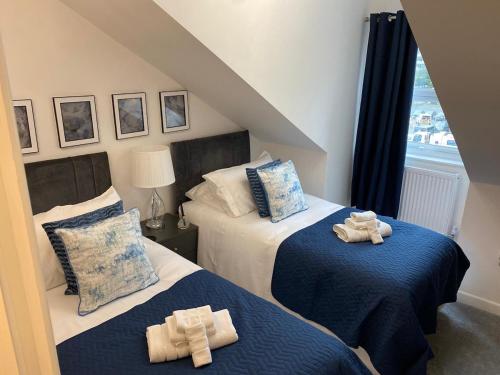 a bedroom with two beds with towels on them at Charming 2- Bedroom Apartment in Watford