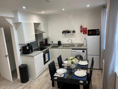 a kitchen with a table and a dining room at Charming 2- Bedroom Apartment in Watford