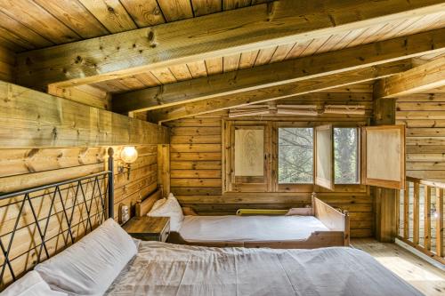 a bedroom with two beds in a log cabin at Habitacions Mas Fuselles in Girona