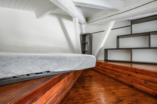 Ce lit se trouve dans un dortoir doté de parquet. dans l'établissement Le Nid d'Aigle de la Comédie, à Montpellier