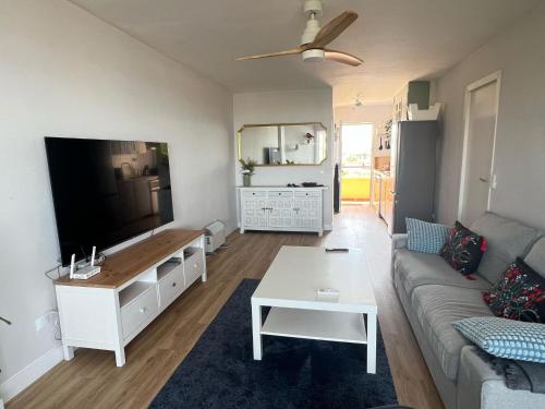a living room with a couch and a flat screen tv at Calypso Holidays II in Sitio de Calahonda