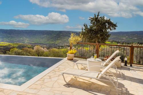 a patio with chairs and a swimming pool with a view at Casale Xenia in Lyso