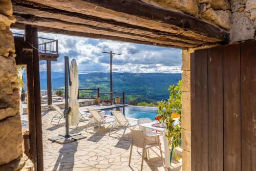 a patio with chairs and a table and a pool at Casale Xenia in Lyso