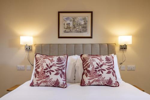 a bed with two pillows and a picture on the wall at Divico in York