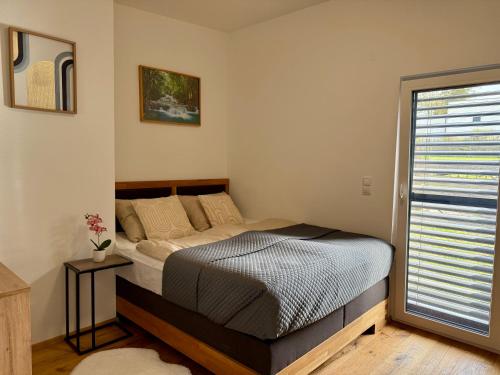 een slaapkamer met een bed en een raam bij Mc Home Neues und sonniges Doppelhaus, Top 1 mit grosse Terrasse und E-Ladestation in Dobl bei Graz in Dobl