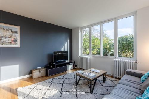 un salon avec un canapé et une télévision dans l'établissement Family Stay - In the Heart of Honfleur 8 guests Private Garden, à Honfleur