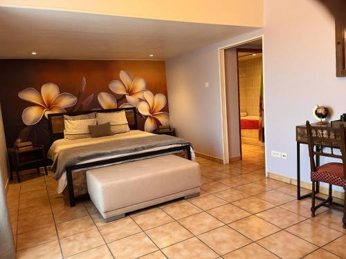 une chambre avec un lit avec une fresque florale sur le mur dans l'établissement Maison M, à Surin
