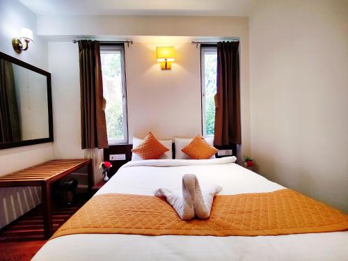 a bedroom with a bed with two towels on it at Jo'stel Dream Glory Hotel and Bar - Near MG Marg in Gangtok