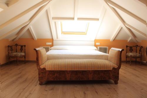 カカベロスにあるHostal Siglo XIXの窓と椅子2脚が備わるドミトリールームのベッド1台分です。