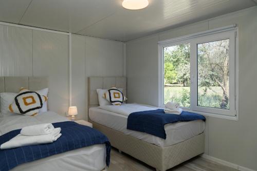 two beds in a room with a window at KRAPEC Beach in Krapets