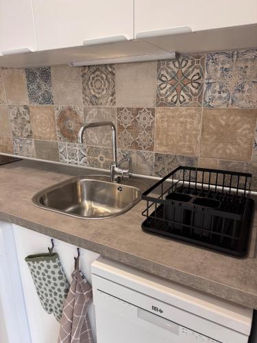 - une cuisine avec un évier en acier inoxydable et du carrelage dans l'établissement Appartement au cœur du village, à Murato