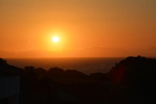 a sunset over the ocean with the sun in the sky at Panorama in Skafidia