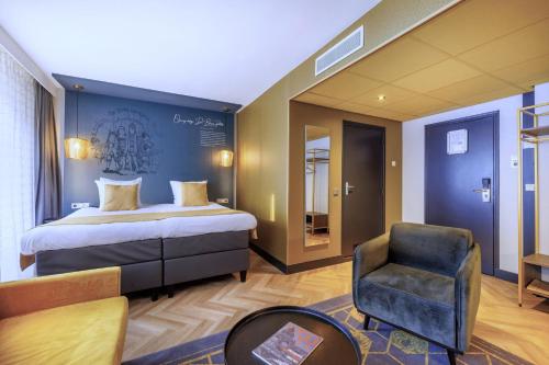 een hotelkamer met een bed en een stoel bij Hotel Die Port van Cleve in Amsterdam