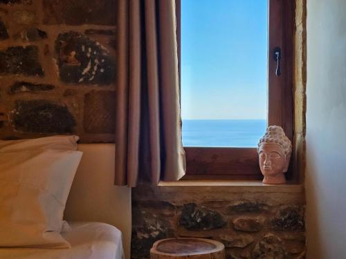 a bedroom with a window with a statue of a head at The House of Life in Pírgos