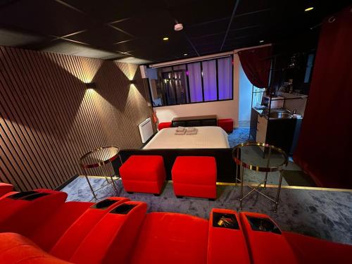 Cette chambre comprend un lit et des chaises rouges. dans l'établissement 4K cinema, Jacuzzi, à Mérignac