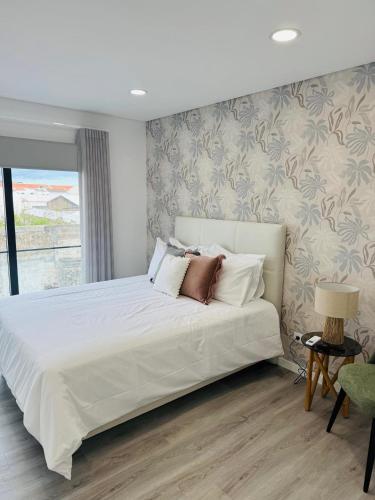a bedroom with a large white bed and a window at Bella Casa Bed and Breakfast in Ponta Delgada