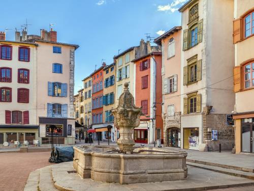 a fountain in the middle of a city with buildings at ibis Styles Le Puy en Velay in Le Puy en Velay