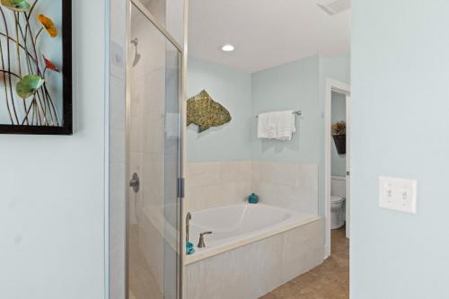 a white bathroom with a tub and a shower at The Vue by Panhandle Getaways in Mexico Beach