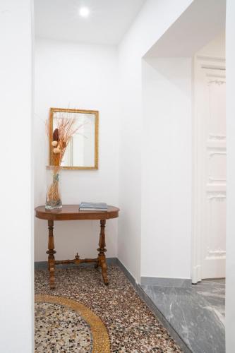 a table with a mirror and a vase on it at L'angolo di Luccoli in Genova