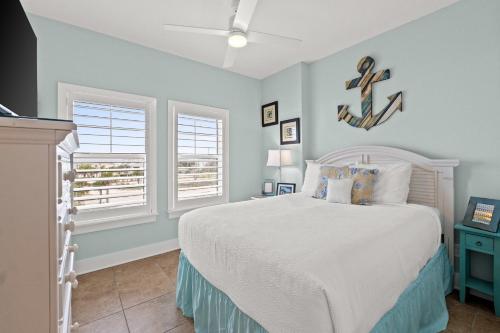 a bedroom with a bed and two windows at The Vue by Panhandle Getaways in Mexico Beach