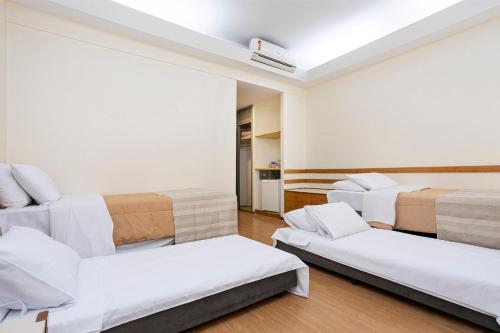 a room with three beds and a couch at Nikkey Palace Hotel in Sao Paulo