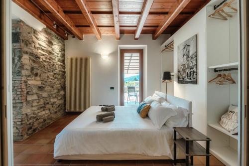 a bedroom with a large bed and a brick wall at Crotto Polirolo by "The House Of Travelers" in Cernobbio