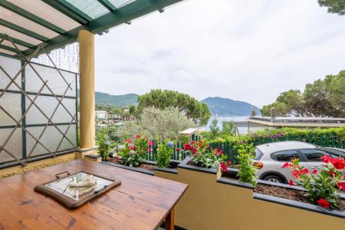 a balcony with a table and flowers and a car at [Terrazza sul mare] B.View56 in Recco