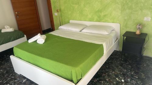 a bedroom with a white bed with a green blanket at Marconi Rooms and Apartments in Verona