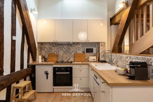 une cuisine avec des armoires blanches et un évier dans l'établissement Le Séjour Honfleurais 3 Duplex with Local Charm City Center 4 Guests, à Honfleur