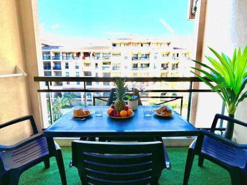 - une table bleue avec des fruits sur le balcon dans l'établissement Le Cannes Beach 408 - cosy avec balcon & piscine, à Cannes