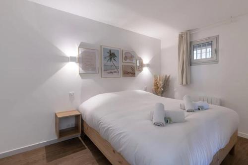 une chambre avec un grand lit blanc avec deux oreillers dans l'établissement Le Cannes Beach 496, à Cannes