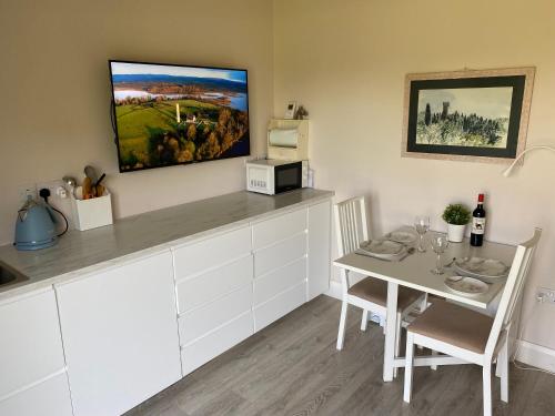 a kitchen with a table and a dining room at Deerpark Stables in Highstreet