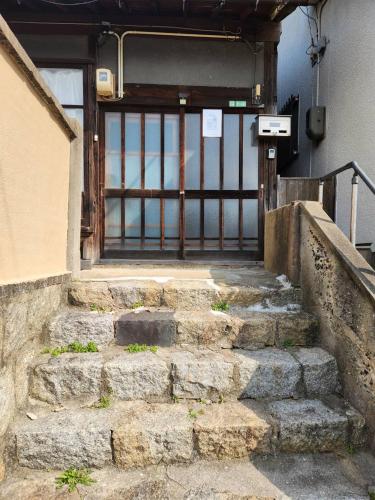 a set of stone stairs leading to a door at おとまりどころ下関本町 in Shimonoseki