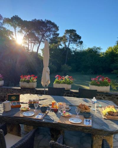 a wooden table with food and wine glasses on it at Les Volets Violets in Salles