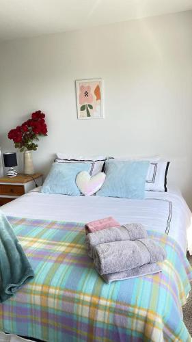 a bedroom with a bed with towels on it at Central located new build 3 bed rooms entire house in Oamaru