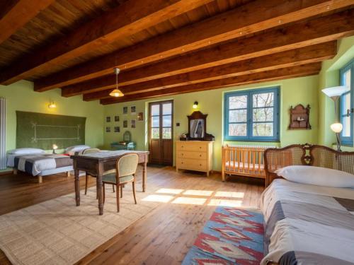a bedroom with two beds and a table in a room at Agriturismo La Rovere - Casale De Rovere in Cossano Belbo