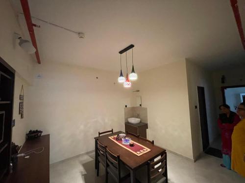 a room with a table and chairs and two lights at Emmanuel in Nagpur