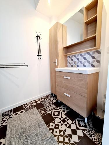 La salle de bains est pourvue d'un lavabo et de carrelage. dans l'établissement La Petite Maison Tourangelle, à Cheillé