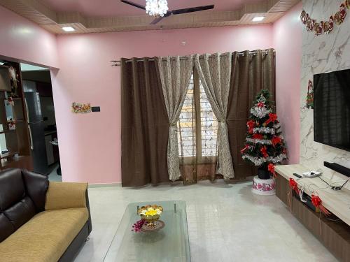 a living room with a christmas tree and a couch at Emmanuel in Nagpur